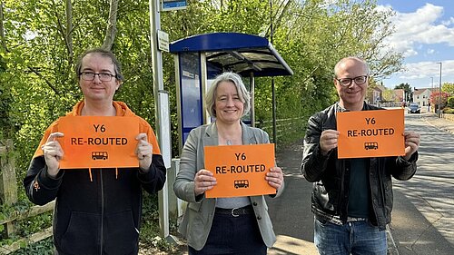 Jon, Claire and Tristan holding "Y6 Re-routed" signs